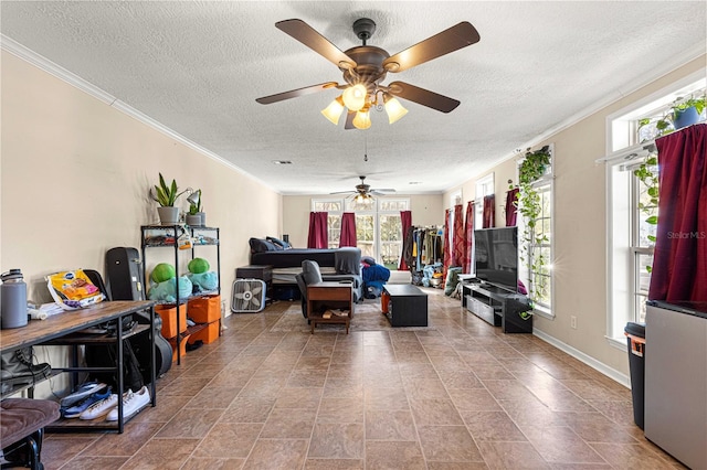 living room with a textured ceiling, a wealth of natural light, ornamental molding, and ceiling fan