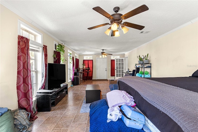 tiled bedroom featuring a textured ceiling, ceiling fan, and ornamental molding