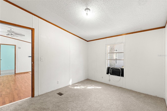 carpeted spare room with ceiling fan, cooling unit, a textured ceiling, and ornamental molding