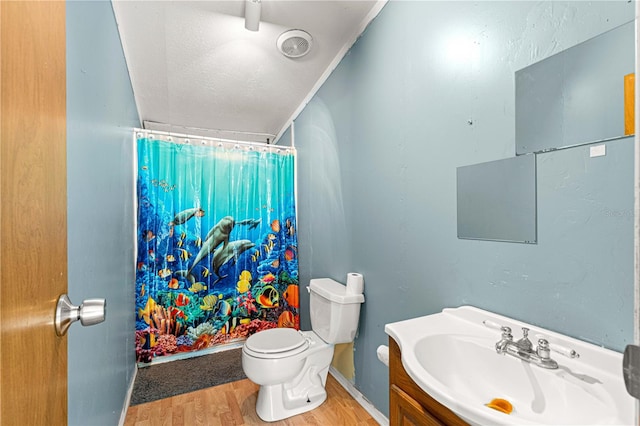 bathroom featuring walk in shower, toilet, vanity, and hardwood / wood-style flooring