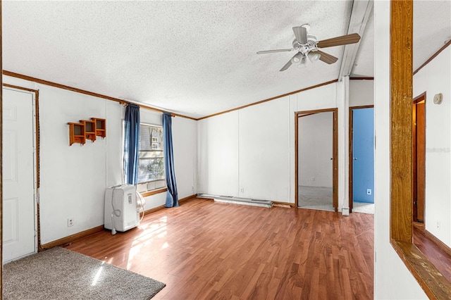 interior space featuring a textured ceiling, light wood-type flooring, and crown molding