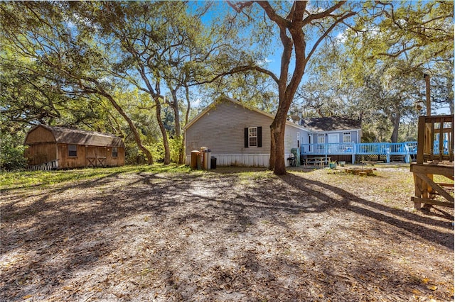 view of side of home featuring a storage unit and a deck