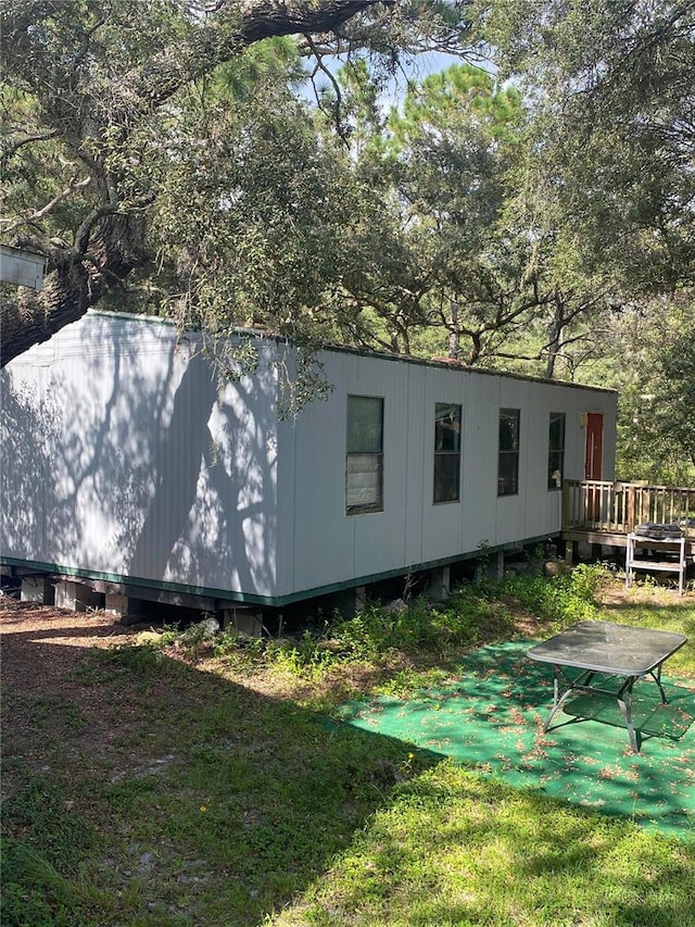 view of side of home featuring a yard and a wooden deck