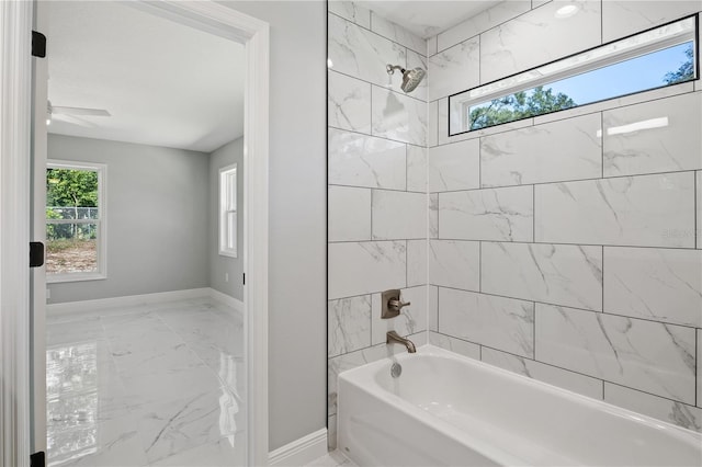 bathroom featuring ceiling fan and tiled shower / bath