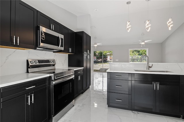 kitchen with appliances with stainless steel finishes, tasteful backsplash, vaulted ceiling, sink, and decorative light fixtures