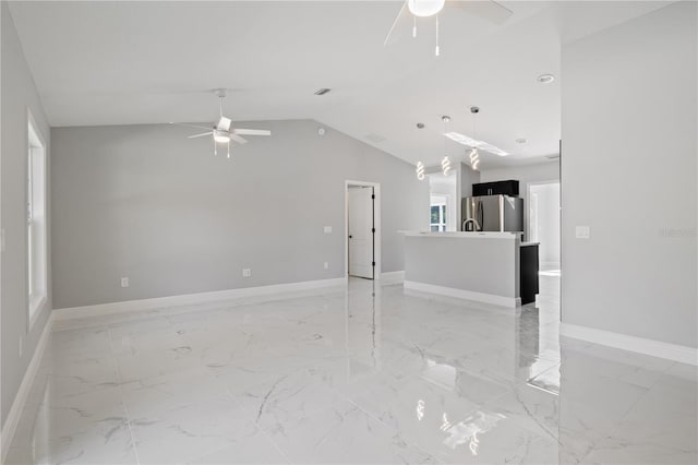 unfurnished living room featuring vaulted ceiling and ceiling fan