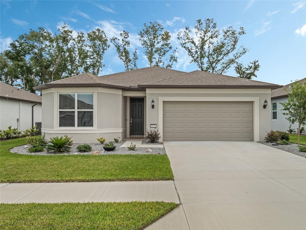 ranch-style house featuring a garage and a front lawn