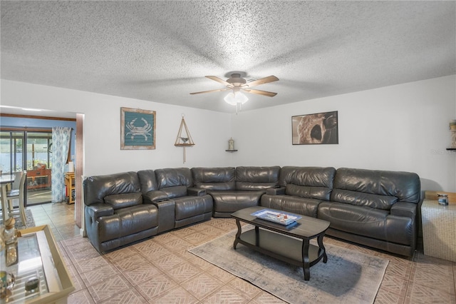 living room featuring ceiling fan and a textured ceiling