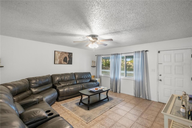 living room featuring a textured ceiling, ceiling fan, and light tile patterned flooring