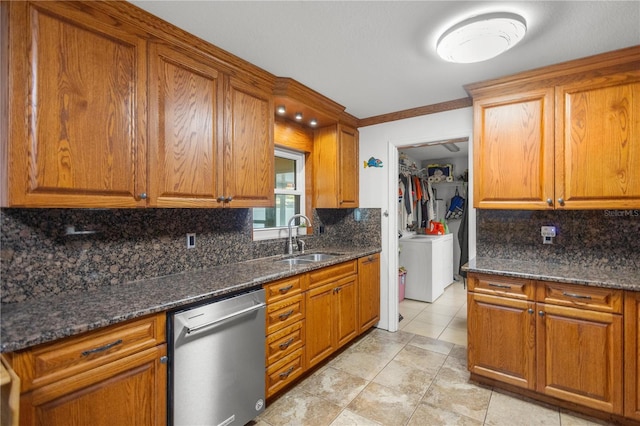 kitchen with dark stone countertops, sink, washer / clothes dryer, and dishwasher