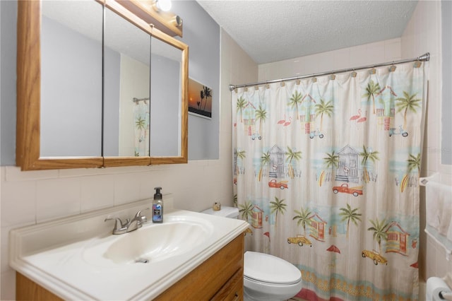 bathroom with toilet, a textured ceiling, tile walls, vanity, and curtained shower