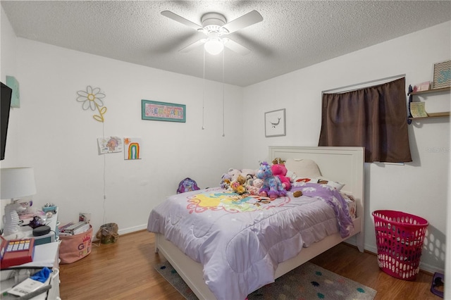 bedroom featuring ceiling fan, hardwood / wood-style floors, and a textured ceiling