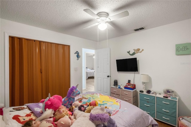 bedroom with ceiling fan and a textured ceiling