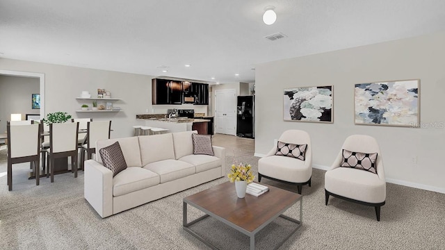 living room with sink and light colored carpet