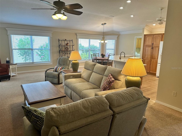 carpeted living room featuring ornamental molding, sink, and a chandelier