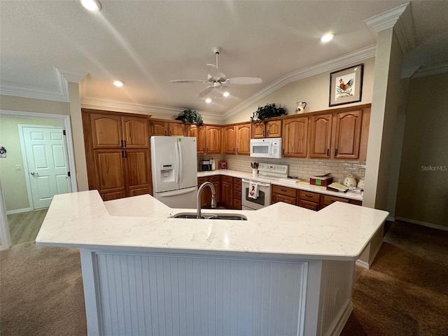 kitchen with sink, dark colored carpet, a large island with sink, lofted ceiling, and white appliances