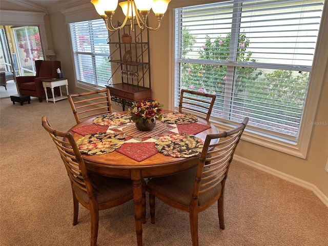 dining area with carpet, plenty of natural light, ornamental molding, and an inviting chandelier