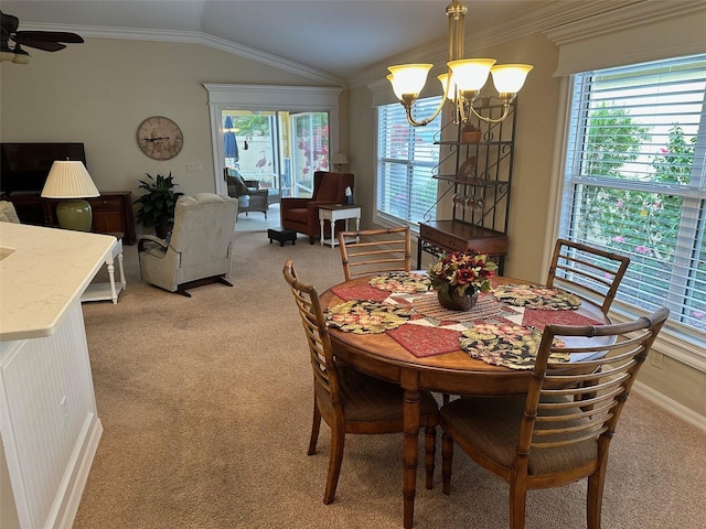 carpeted dining area featuring ceiling fan with notable chandelier, vaulted ceiling, and ornamental molding