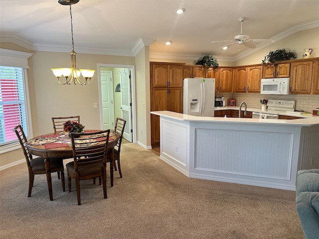 kitchen with decorative light fixtures, light colored carpet, and white appliances