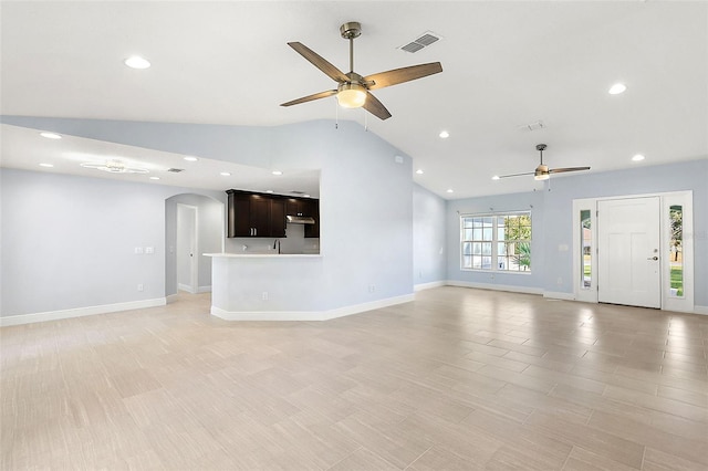 unfurnished living room with ceiling fan, light wood-type flooring, and lofted ceiling