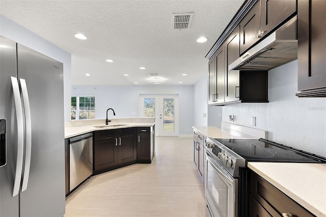 kitchen featuring dark brown cabinetry, french doors, sink, a textured ceiling, and appliances with stainless steel finishes