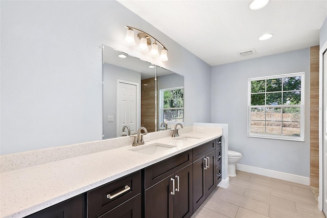 bathroom featuring a wealth of natural light, vanity, wood-type flooring, and toilet