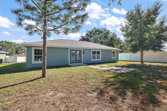 back of house featuring french doors and a lawn