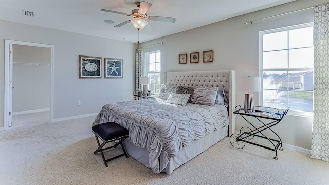 carpeted bedroom with ceiling fan, a spacious closet, and a closet