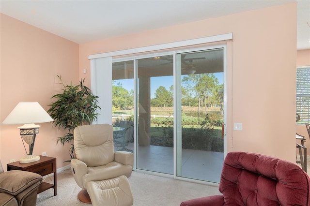 doorway to outside featuring light carpet and a wealth of natural light