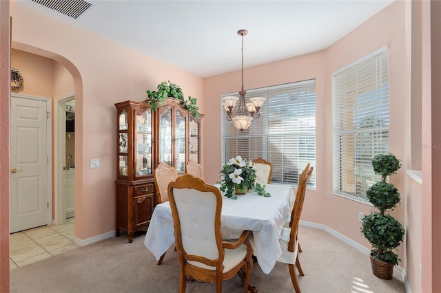 carpeted dining area featuring a notable chandelier