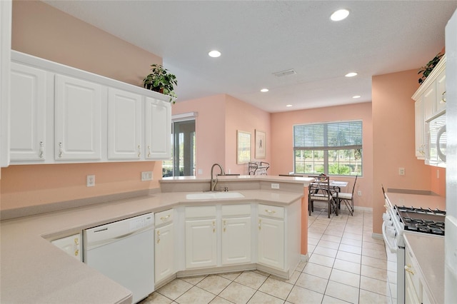 kitchen with a wealth of natural light, white cabinets, and white appliances