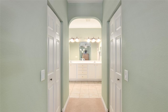 hall featuring light carpet and sink