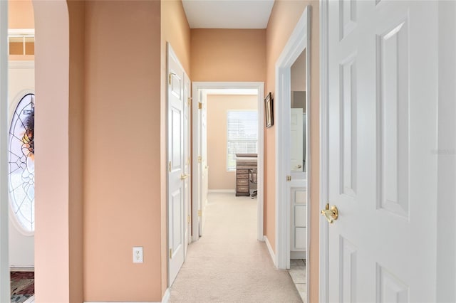 hallway featuring light colored carpet