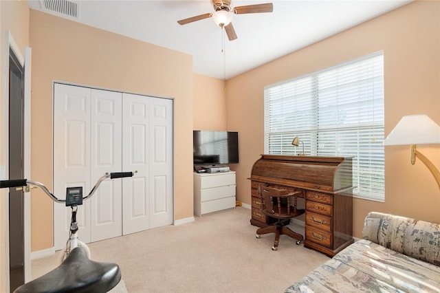 bedroom featuring ceiling fan, light carpet, and multiple windows