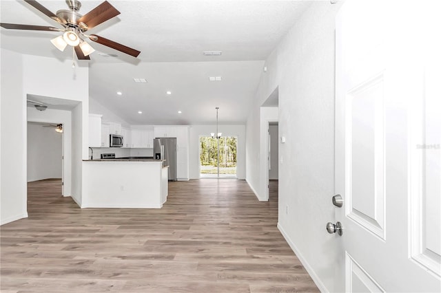 kitchen with ceiling fan with notable chandelier, light hardwood / wood-style floors, white cabinetry, and stainless steel appliances