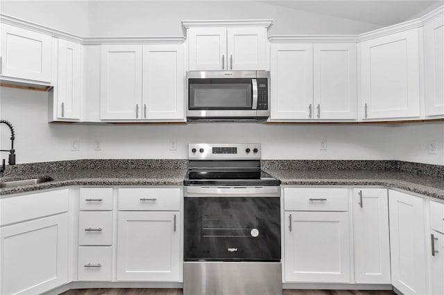 19925 SW Lark Dr, Dunnellon, FL 34431 - kitchen featuring stainless steel appliances, a sink, white cabinets, and vaulted ceiling