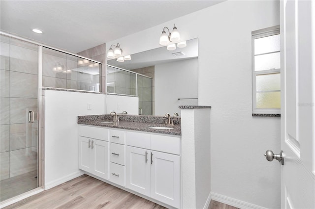 bathroom featuring hardwood / wood-style floors, vanity, and walk in shower