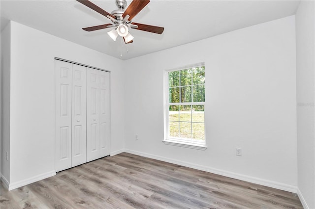 unfurnished bedroom with ceiling fan, a closet, and light hardwood / wood-style floors