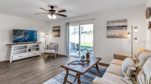 living room featuring ceiling fan and dark wood-type flooring