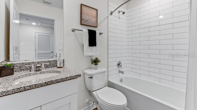 full bathroom with vanity, tiled shower / bath combo, and toilet