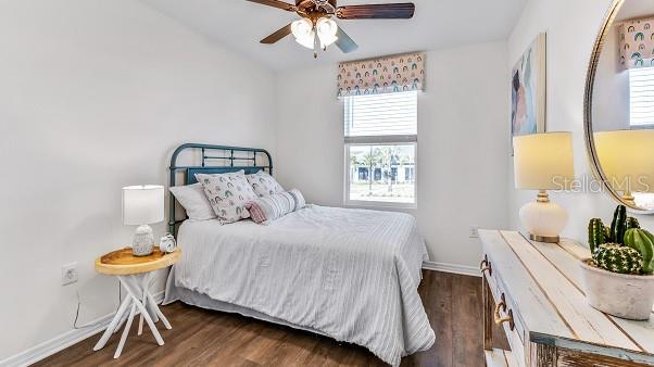 bedroom with dark hardwood / wood-style floors, ceiling fan, and lofted ceiling