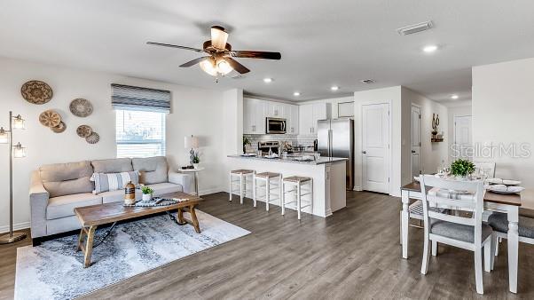 living room with dark hardwood / wood-style floors and ceiling fan