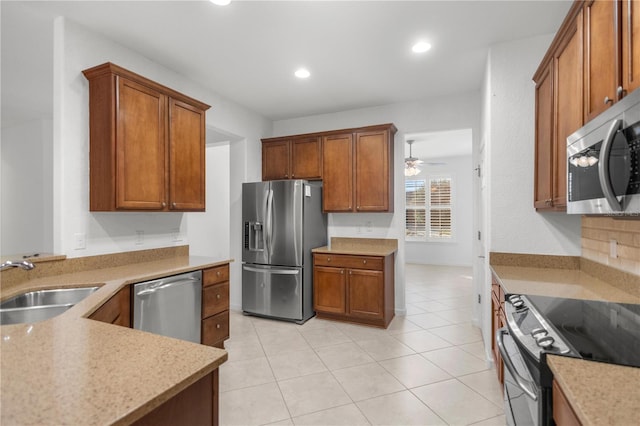 kitchen featuring ceiling fan, sink, backsplash, light tile patterned flooring, and appliances with stainless steel finishes