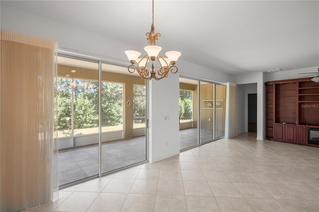 interior space featuring ceiling fan with notable chandelier, a healthy amount of sunlight, and light tile patterned floors