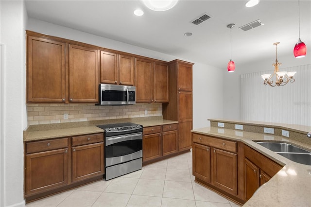 kitchen featuring sink, decorative light fixtures, appliances with stainless steel finishes, tasteful backsplash, and a notable chandelier