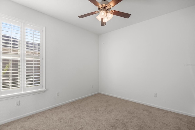 carpeted empty room with a wealth of natural light and ceiling fan