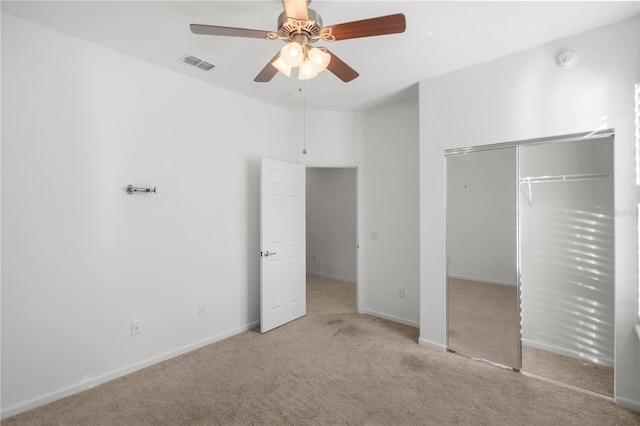 unfurnished bedroom with light carpet, a closet, and ceiling fan