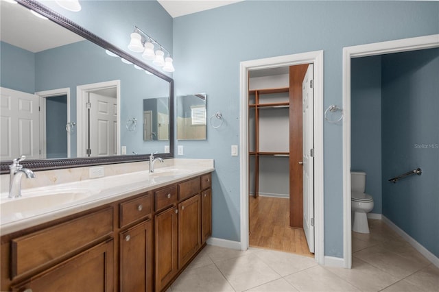 bathroom with tile patterned flooring, vanity, and toilet