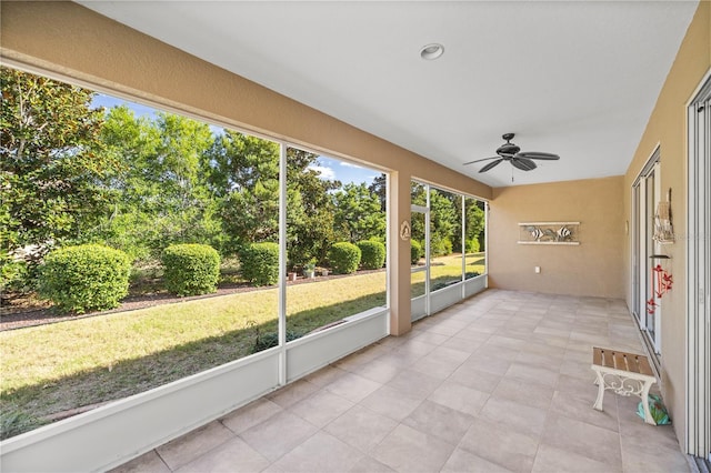 unfurnished sunroom with ceiling fan