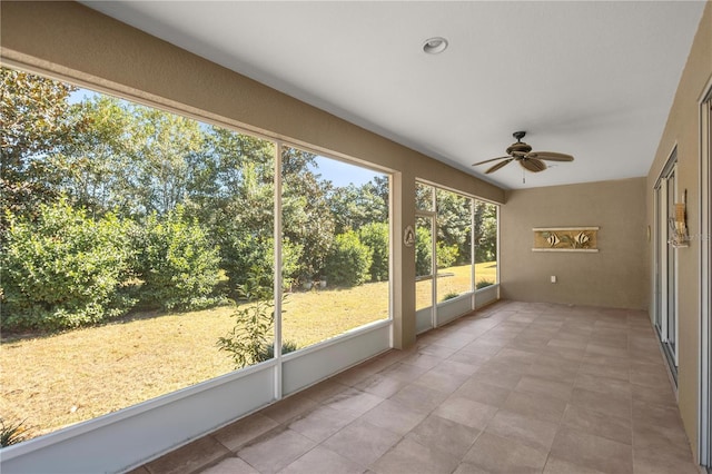 unfurnished sunroom with ceiling fan